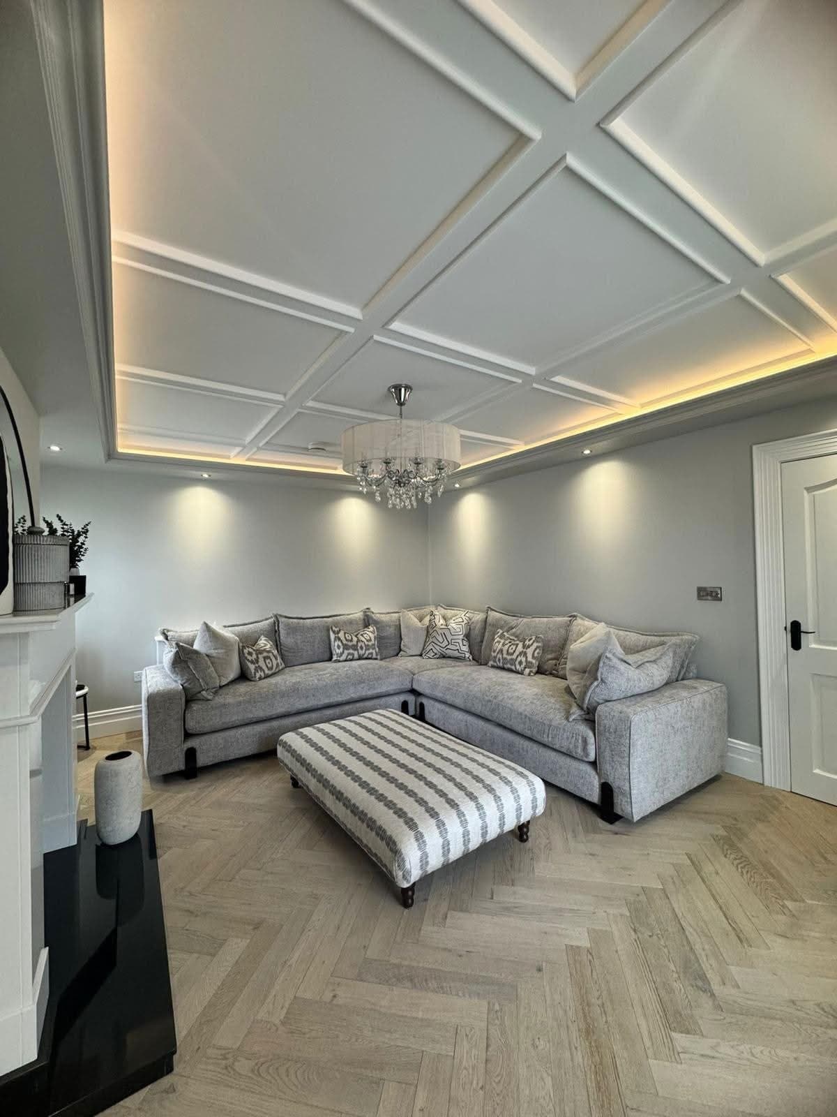 Coffered ceiling grid with perimeter LED lighting in a grey lounge