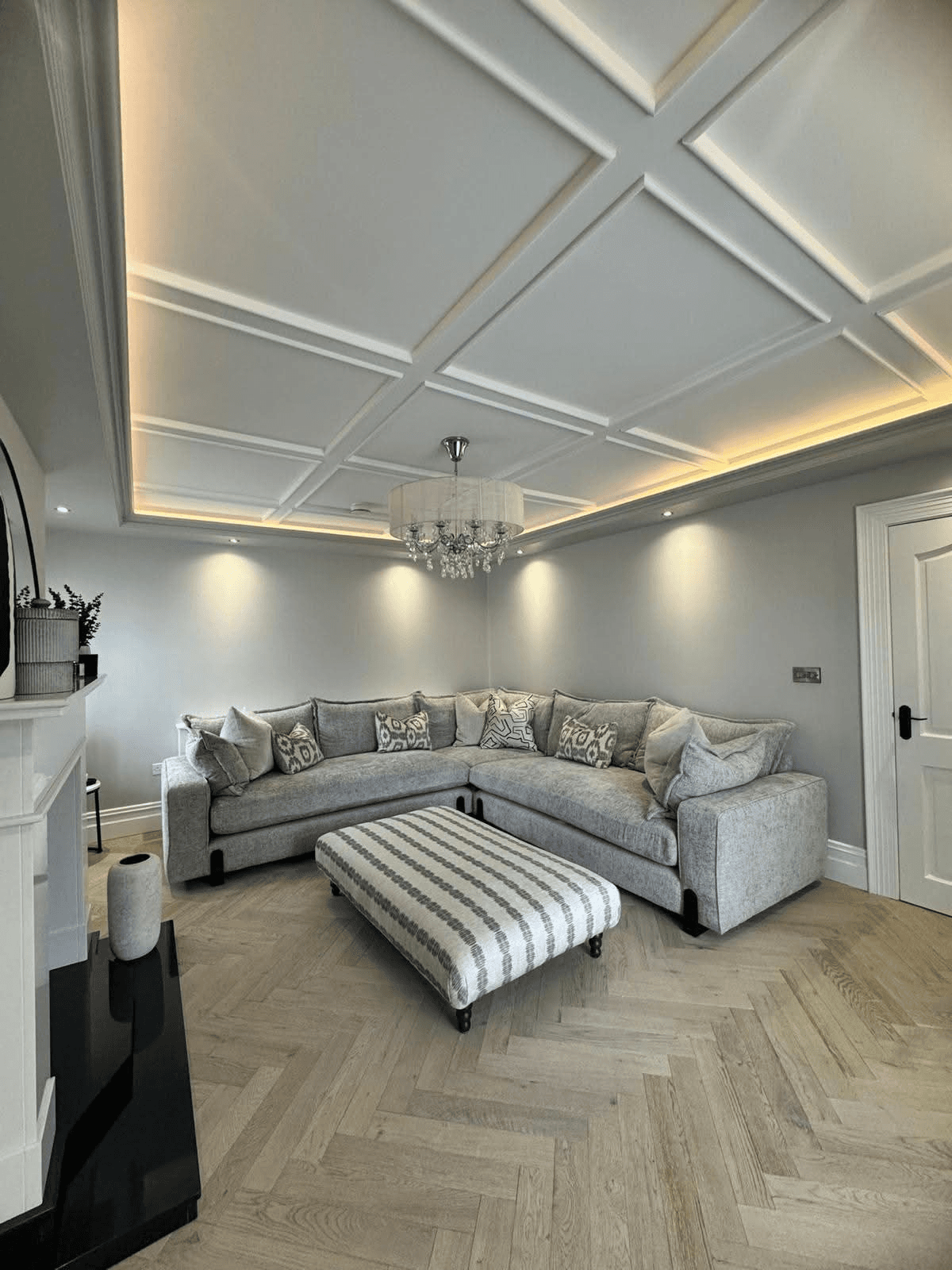 Coffered ceiling grid with perimeter LED lighting in a grey lounge