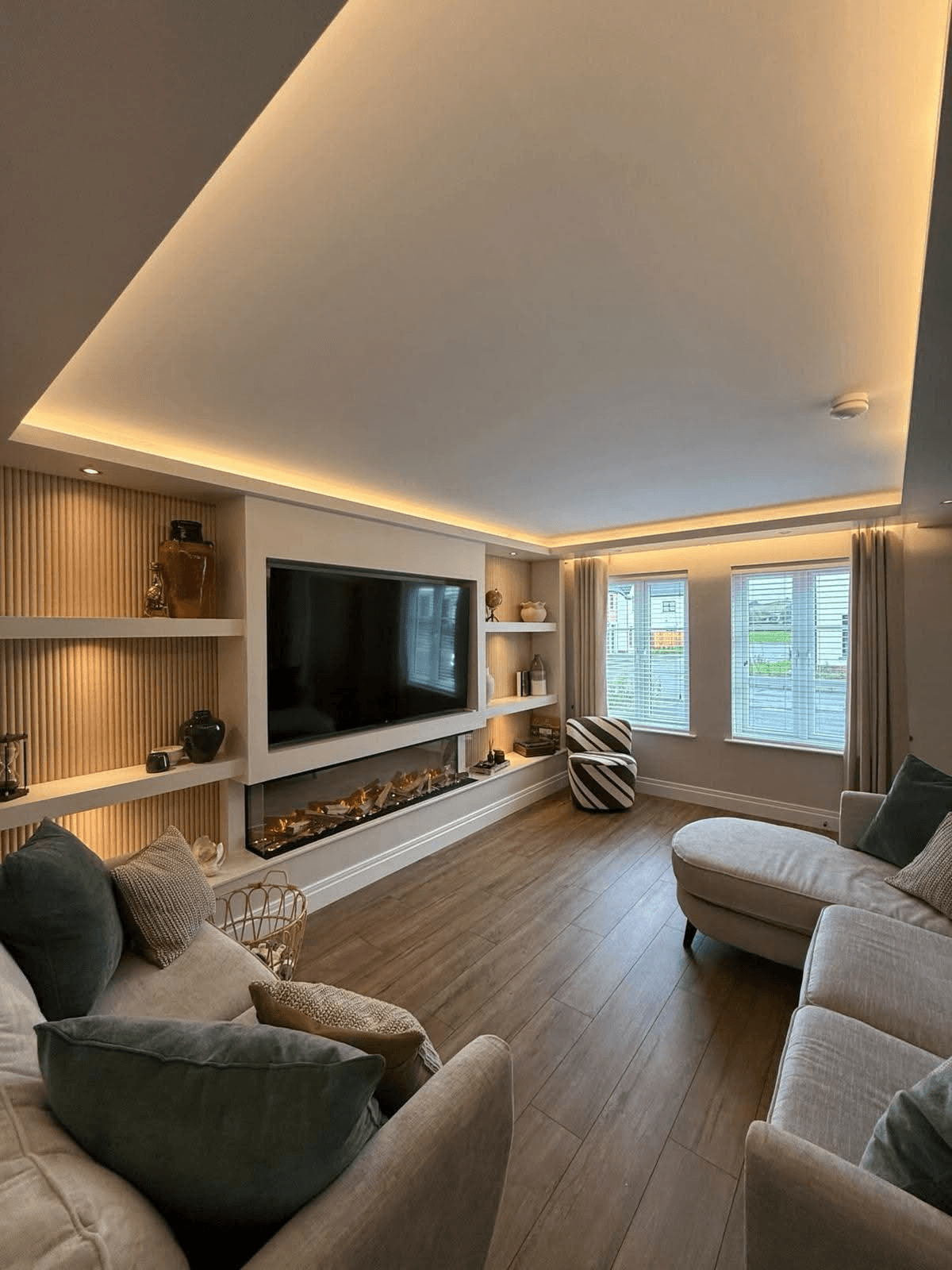 Media wall with linear fireplace, integrated shelving and recessed ceiling lighting